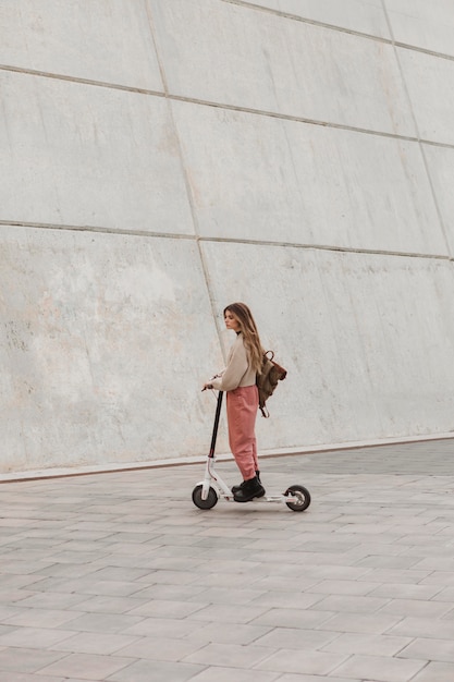 Mujer joven montando un scooter eléctrico