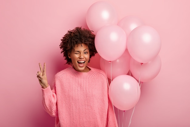 Mujer joven morena sosteniendo globos