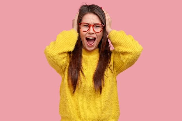 Mujer joven morena en suéter amarillo