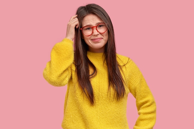 Mujer joven morena en suéter amarillo