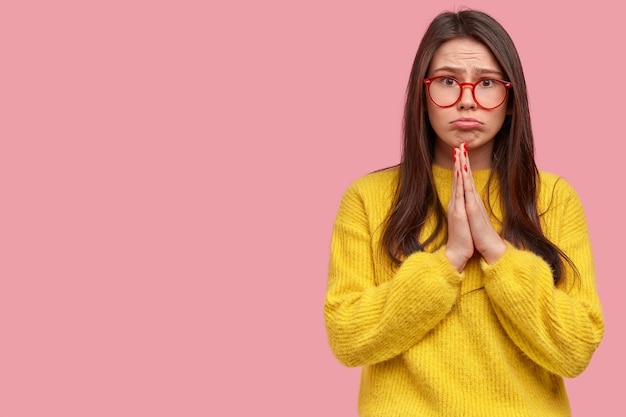 Mujer joven morena en suéter amarillo