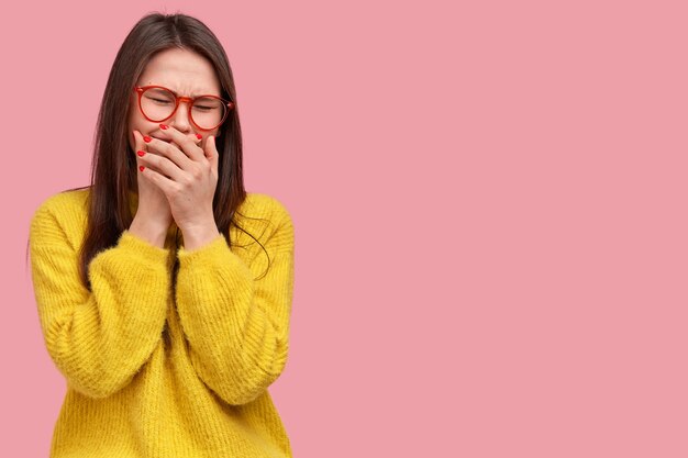 Mujer joven morena en suéter amarillo