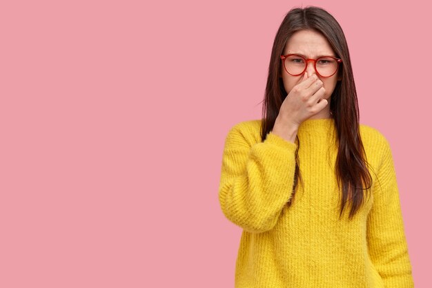 Mujer joven morena en suéter amarillo