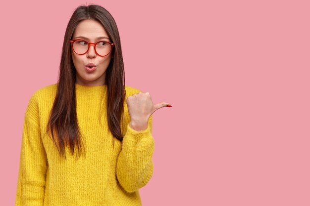 Mujer joven morena en suéter amarillo