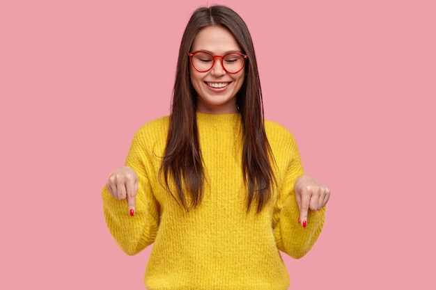 Mujer joven morena en suéter amarillo