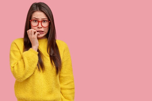 Mujer joven morena en suéter amarillo