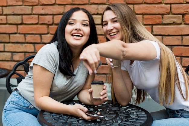 Mujer joven mostrando algo a su amiga