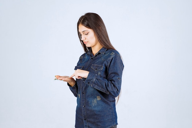 Mujer joven mostrando algo en su mano abierta