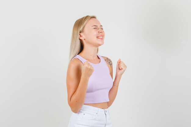 Mujer joven mostrando gesto ganador en camiseta