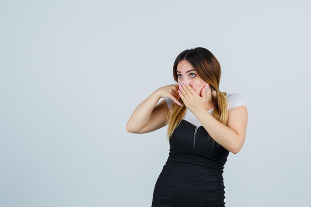 Mujer joven mostrando gesto de teléfono y mirando sorprendido