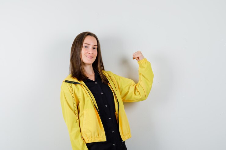 Foto gratuito mujer joven mostrando músculos