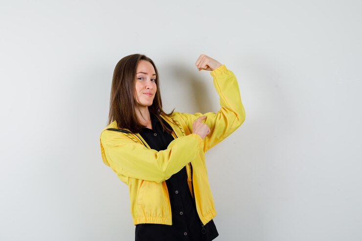 Foto gratuito mujer joven mostrando músculos