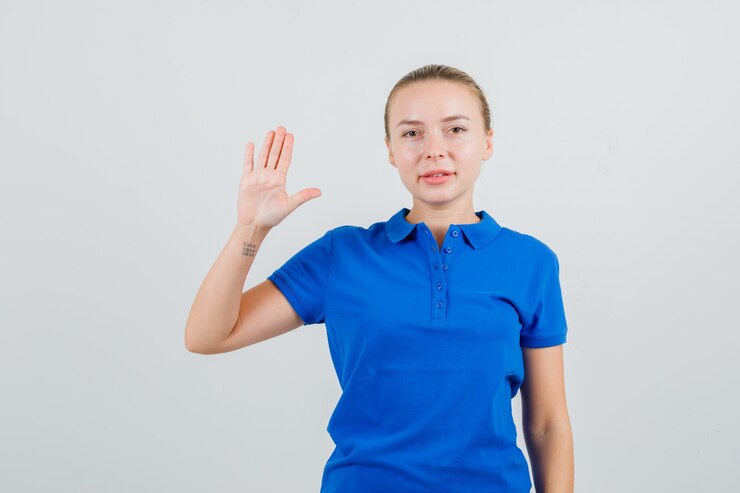 Foto gratuito mujer joven mostrando la palma en camiseta azul y mirando confiado