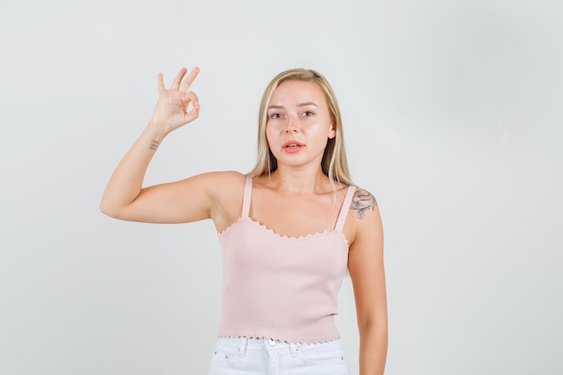 Mujer joven mostrando signo ok en camiseta