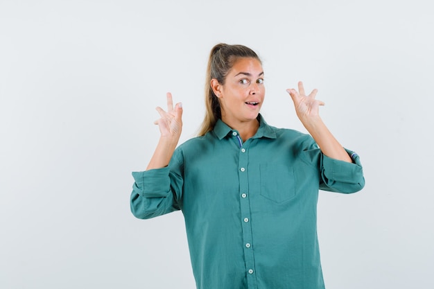 Mujer joven mostrando signos de ok en blusa verde y luciendo lindo