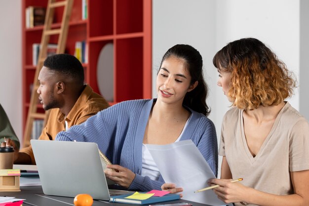 Mujer joven mostrando a su amiga sus notas durante la sesión de estudio