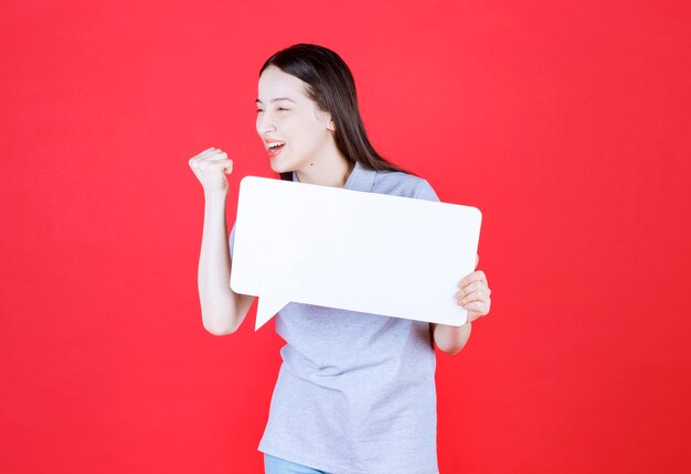 Mujer joven motivada sosteniendo junta y aprieta su puño