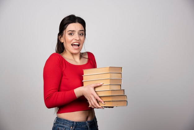 mujer joven con muchos libros