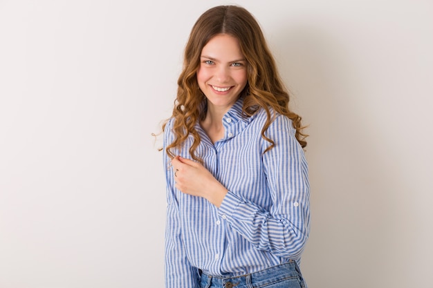 Mujer joven muy elegante posando en traje de estilo denim en blanco