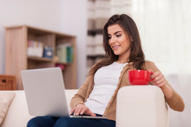 Mujer joven navegando por la red en casa