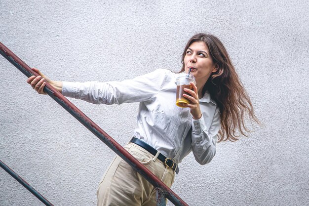 Foto gratuita mujer joven de negocios cerca de las escaleras con una taza de café