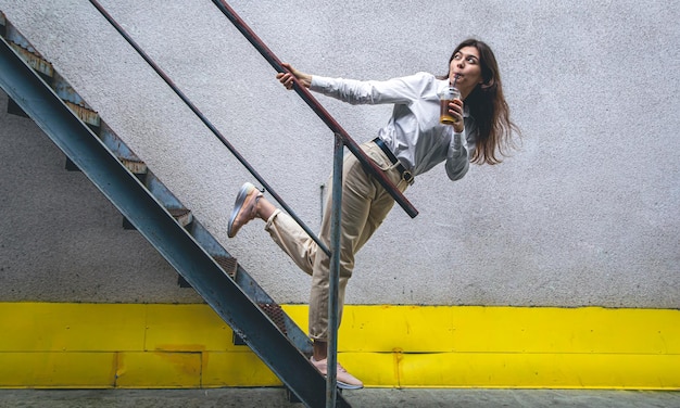 Foto gratuita mujer joven de negocios cerca de las escaleras con una taza de café