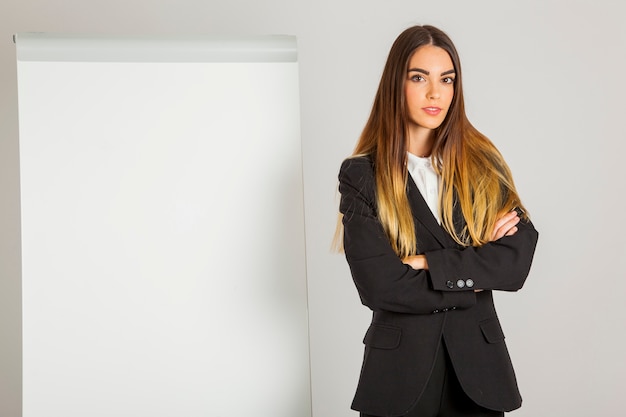 Foto gratuita mujer joven de negocios posando con pizarra