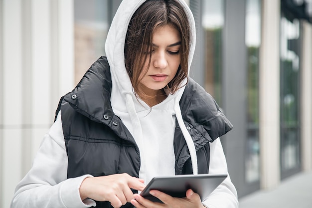 Mujer joven de negocios con una tableta en el fondo del edificio