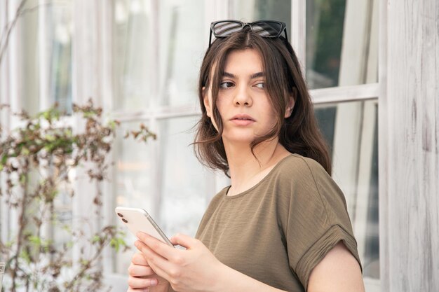 Mujer joven de negocios con un teléfono inteligente en sus manos en un caluroso día de verano