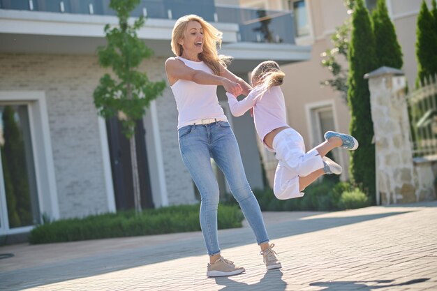Mujer joven y una niña divirtiéndose en la calle