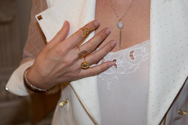 Mujer joven novia con anillos brillantes en collares y pulseras de oro