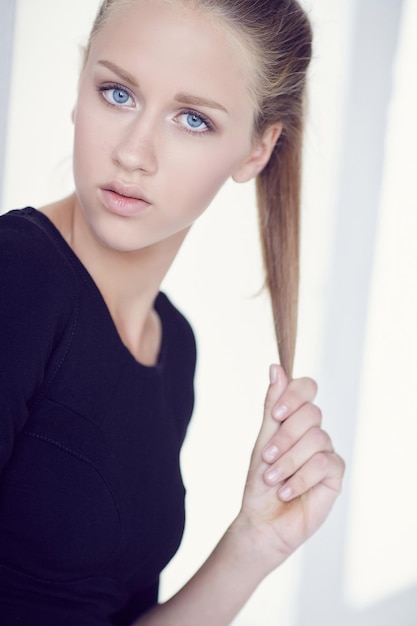 Foto gratuita mujer joven con ojos azules en un vestido negro.