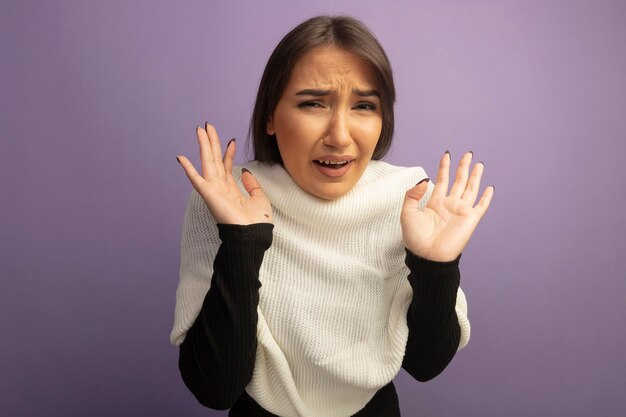 Mujer joven con pañuelo blanco asustado con las manos levantadas