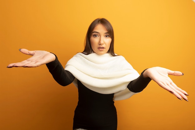 Mujer joven con pañuelo blanco confundido con los brazos extendidos