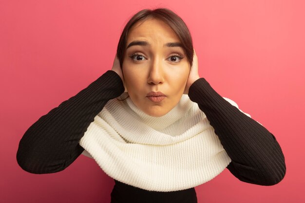 Mujer joven con pañuelo blanco confundido con las manos en la cabeza