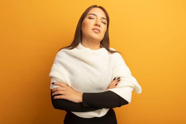 Mujer joven con pañuelo blanco con expresión de confianza con los brazos cruzados sobre el pecho