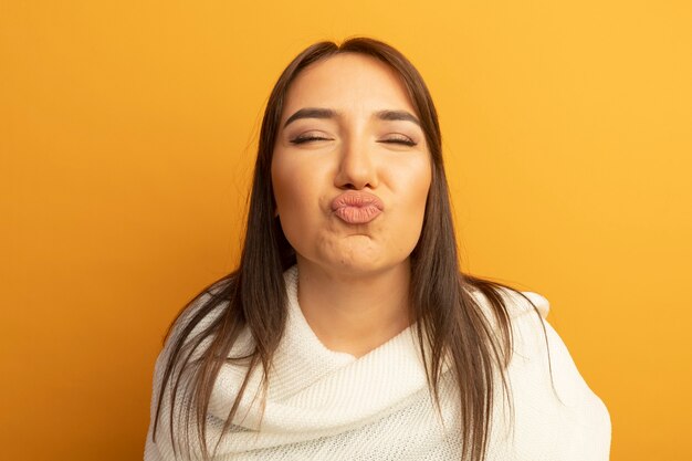 Mujer joven con pañuelo blanco manteniendo los labios como si fuera a besar