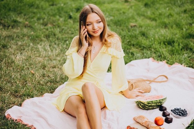 Mujer joven en el parque comiendo sandía