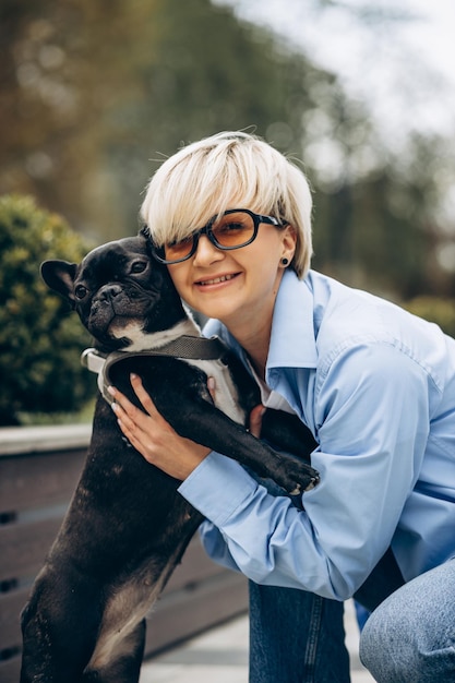 Foto gratuita mujer joven paseando con su mascota bulldog francés