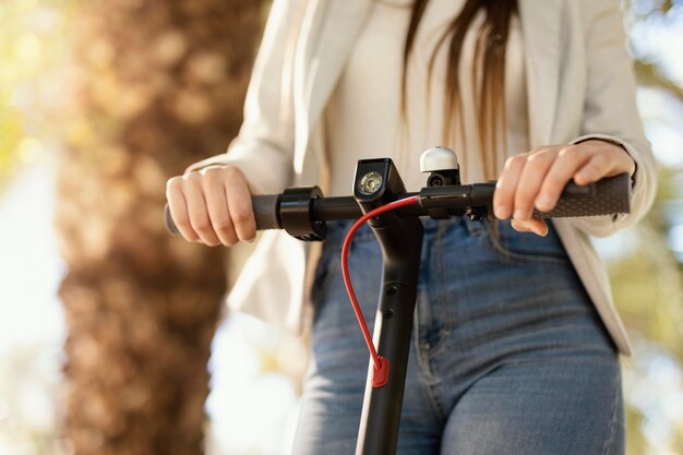 Mujer joven paseos en un scooter eléctrico en la ciudad