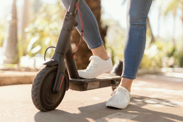 Mujer joven paseos en un scooter eléctrico en la ciudad