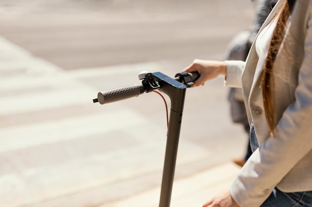 Mujer joven paseos en un scooter eléctrico en la ciudad