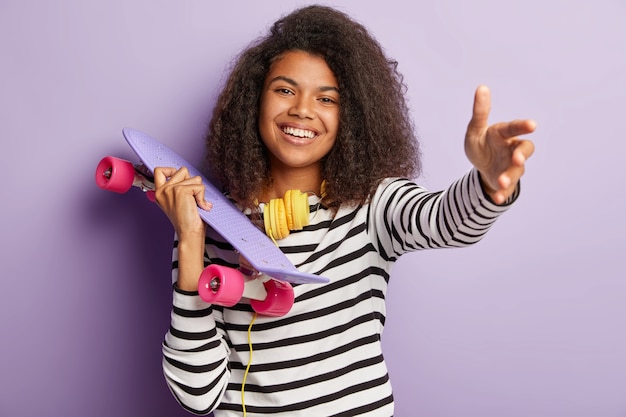 Mujer joven patinador posando con tabla larga