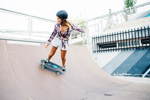 Mujer joven patinando con casco