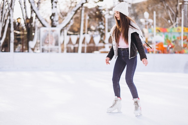 Mujer joven patinando en una pista en un centro de la ciudad
