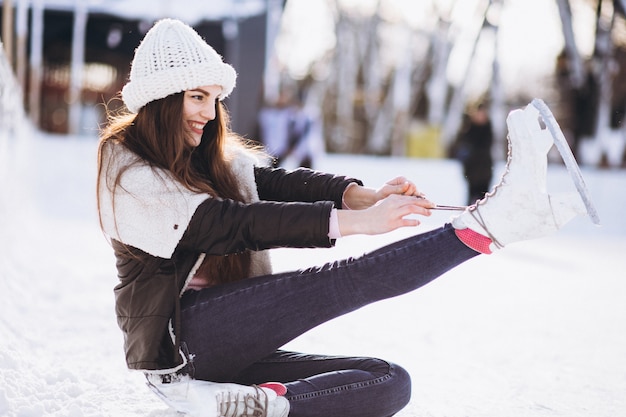 Mujer joven patinar sobre hielo en una pista en un centro de la ciudad