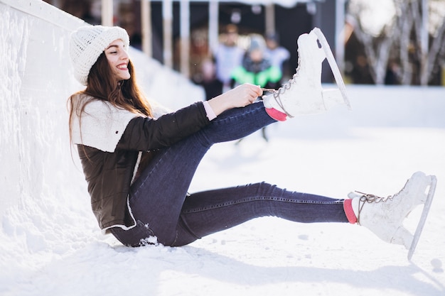 Mujer joven patinar sobre hielo en una pista en un centro de la ciudad