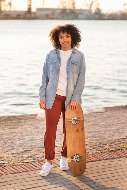 Foto gratuita mujer joven con patineta