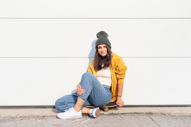 Foto gratuita mujer joven con patineta