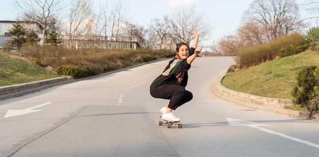 Foto gratuita mujer joven con patineta